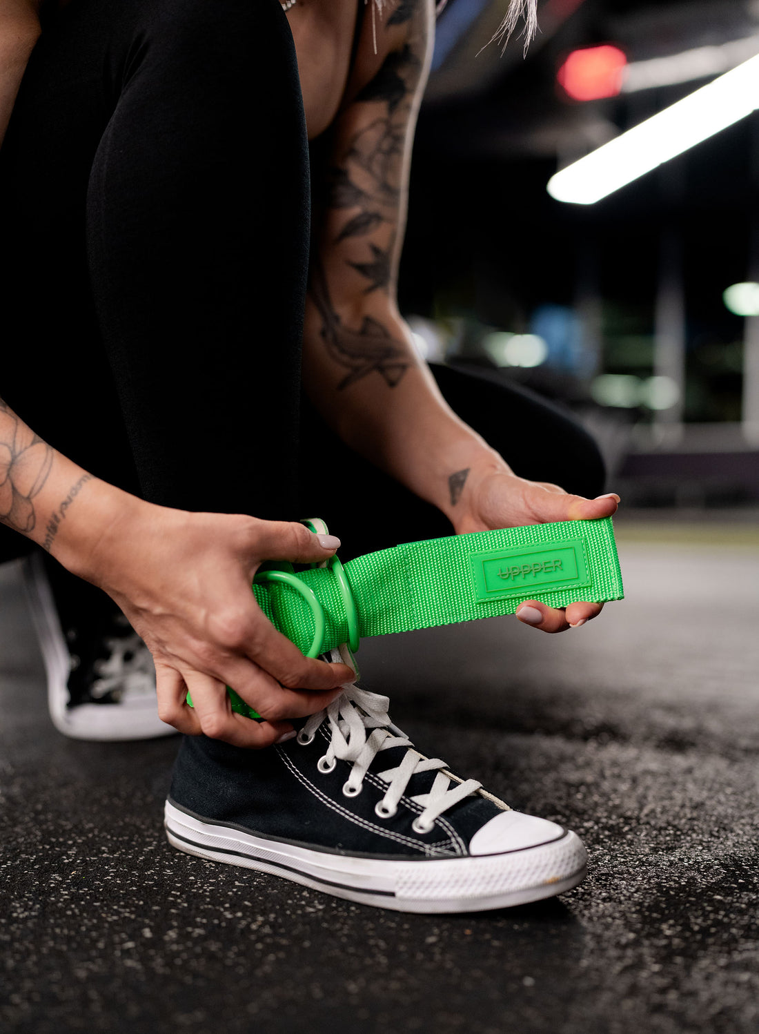 woman putting on uppper ankle straps for cable machine